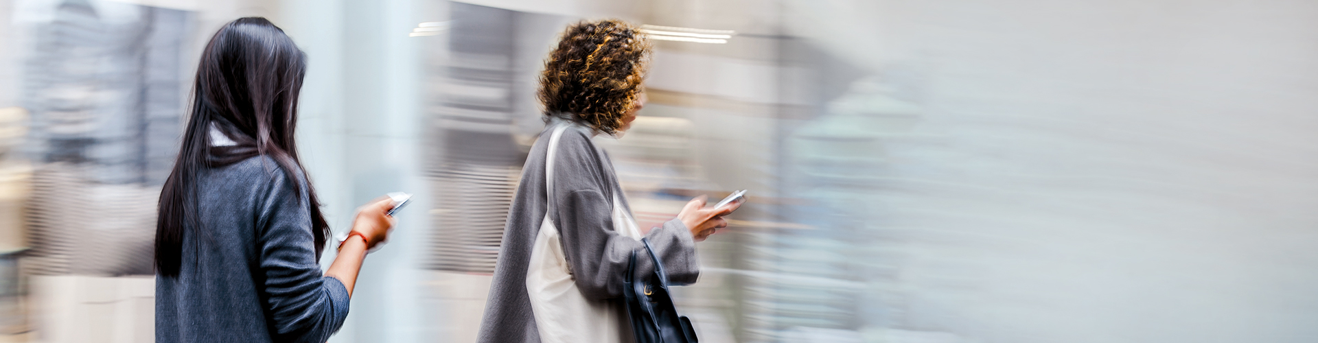 Kopp-Kirsamer - Slider_KKW20_F05_AdobeStock-131258965_Zwei-Frauen-mit-Smartphones-laufend-an-Straße-entlang